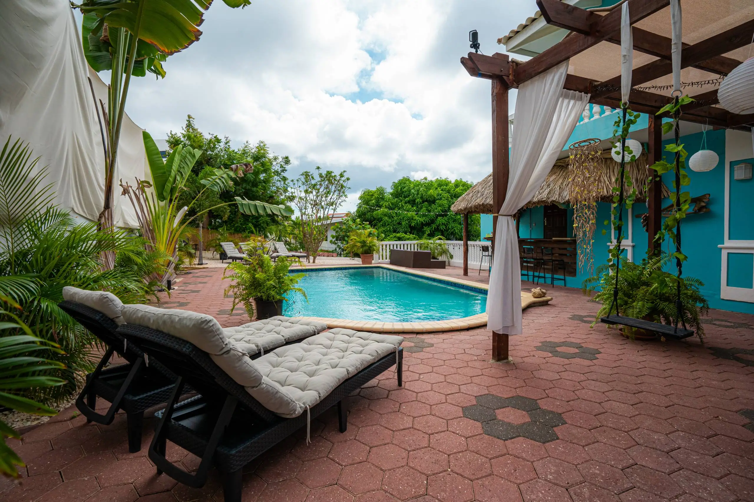 Casa Leonore’s pool, surrounded by tropical greenery and sun loungers.