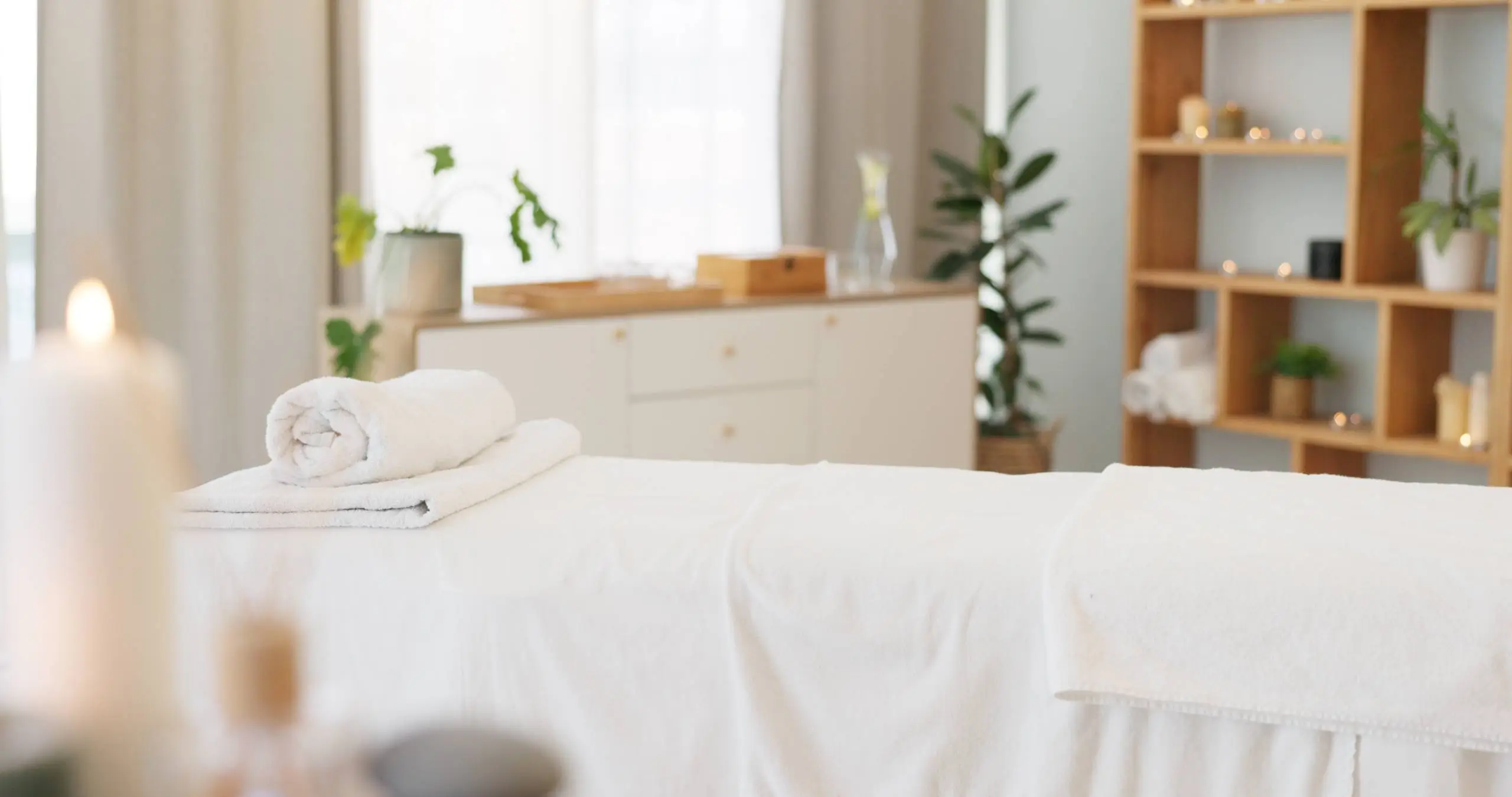 A peaceful massage room with soft lighting, neatly rolled towels, and a serene ambiance, offering professional massage therapy for ultimate relaxation in Curaçao.